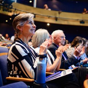 Woman sitting in an audience clapping